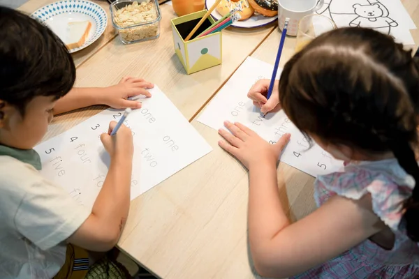 Ablam ve abim evde ödevlerini yaparken birbirlerine yardım ediyorlar..