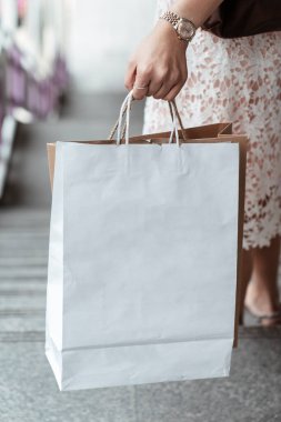Beyaz alışveriş çantası taşıyan bir kadının merdivenlerden inişini yakından çek. Boşluğu kopyala.