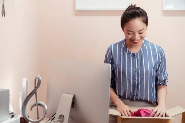 Sevkiyat kutusunu açarken gülümseyen Asyalı Taylandlı kadın.