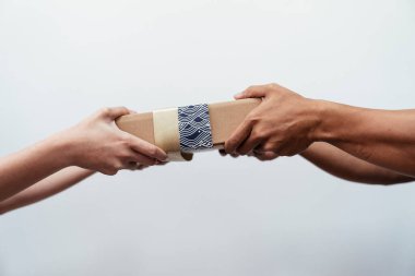 Eller beyaz arka planda hediye paketi veriyor. Hediyeyi iki elinle ver..