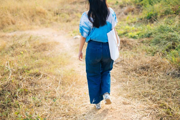 소녀의 흰색과 파란색 넥타이 사진은 초원에서 캔버스 가방을 — 스톡 사진