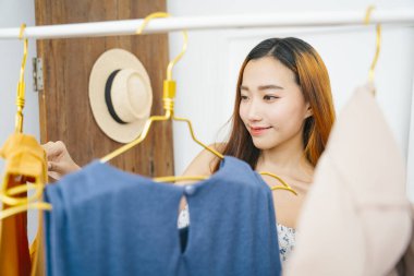 Güzel genç Asyalı kadın alışveriş merkezinden kıyafet alıyor..