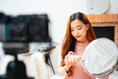 Kameranın önünde sosyal medya için kozmetik video şovu yapan güzel bir kadın..