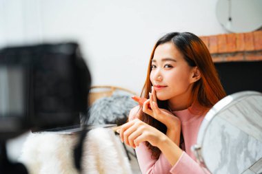 Kameranın önünde sosyal medya için kozmetik video şovu yapan güzel bir kadın..