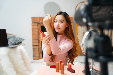 Sosyal medyada izleyicilere ruj izlettiren Asyalı güzel bir kadın etkileyicisi..