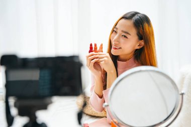 Sosyal medyada izleyicilere ruj izlettiren Asyalı güzel bir kadın etkileyicisi..