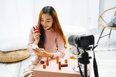 Sosyal medyada izleyicilere ruj izlettiren Asyalı güzel bir kadın etkileyicisi..