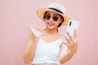 Güzel genç Asyalı kadın akıllı telefonuyla canlı yayın yapıyor..