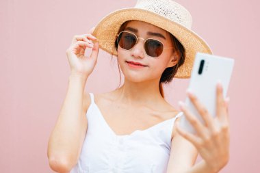 Güzel genç Asyalı kadın akıllı telefonuyla canlı yayın yapıyor..