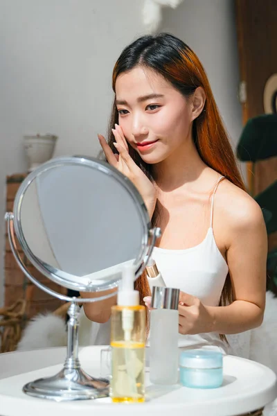 화장을 화장품을 사용하여 거울을 바라보는 아름다운 아시아 — 스톡 사진