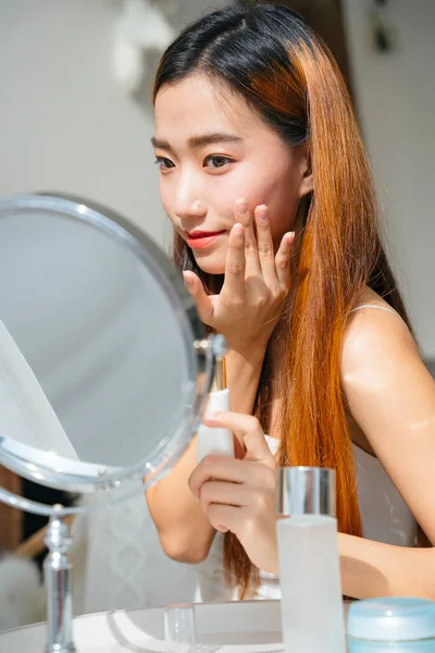 화장을 화장품을 사용하여 거울을 바라보는 아름다운 아시아 — 스톡 사진