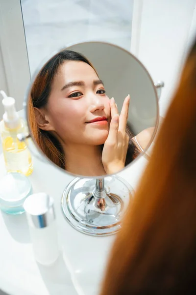 아시아 여인이 거울에 모습을 화장하는 — 스톡 사진