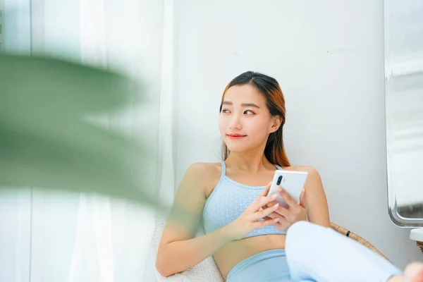 Bonita Esportivo Asiático Mulher Vestindo Sportbra Usando Smartphone Casa — Fotografia de Stock