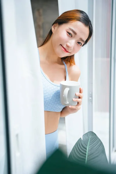 Vacker Sportig Asiatisk Kvinna Bär Sportbra Innehav Kopp Kaffe Hemma — Stockfoto