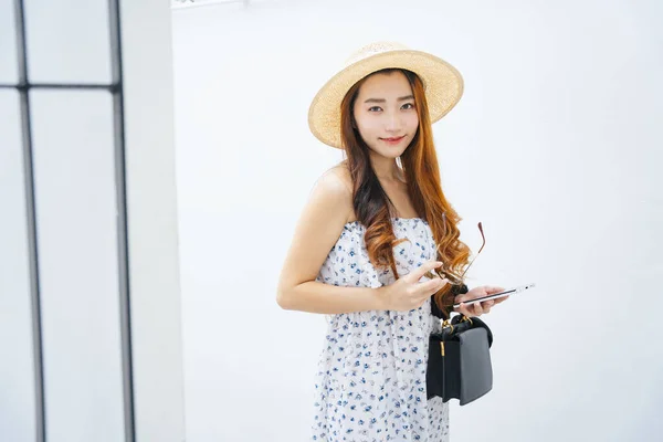 美しいアジアの旅行者の女性の帽子をかぶってサングラスは白い背景に隔離します — ストック写真