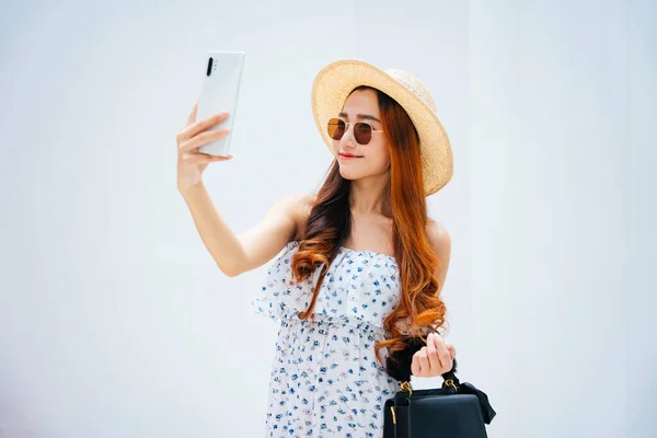 美丽的亚洲女旅行家 戴着太阳镜 头戴安全帽 手持智能手机 — 图库照片