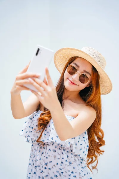 선글라스를 모자를 스마트폰으로 셀카를 아름다운 이시아 여행자 — 스톡 사진