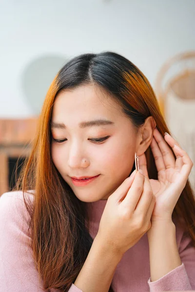 아름다운 여성이 귀고리를 집에서 — 스톡 사진