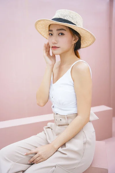 美しいアジアの女性の肖像ピンクの背景に帽子を着用してください — ストック写真