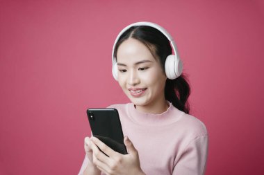 Asyalı genç bir kadının müzik akışı uygulamasında şarkı arayışının portresi.