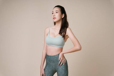 Asyalı genç ve güzel bir kadının portresi spor sutyen takıyor..