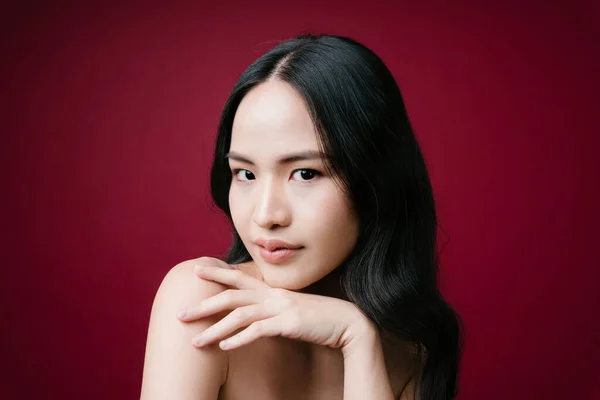 美丽的亚洲女人的肖像 黑头发 自然健康皮肤 红底分离 — 图库照片