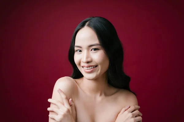 Portrait of beauty asian young woman black hair with perfect skin clean isolated on red background.