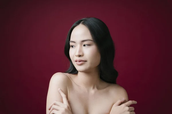 美しさの肖像アジアの若い女性黒髪で完璧な肌のきれいな赤の背景に隔離 — ストック写真