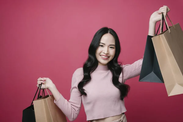 아시아의 애호가들은 쇼핑몰에서 물건을 즐긴다 분홍색 배경에 봉지를 분리하여 불투명 — 스톡 사진