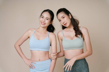 Birlikte poz veren iki Asyalı sporcu kadının portresi..