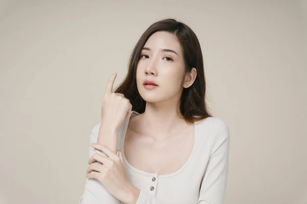 Portret Van Mooie Jonge Aziatische Vrouw Aanraken Arm Isoleren Beige — Stockfoto