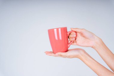 Elinde oyuncak kahve fincanı tutan kadın beyaz arka planda izole edilmiş.. 