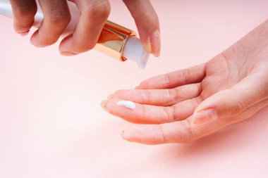 Ellerine krem süren bir kadın eli.