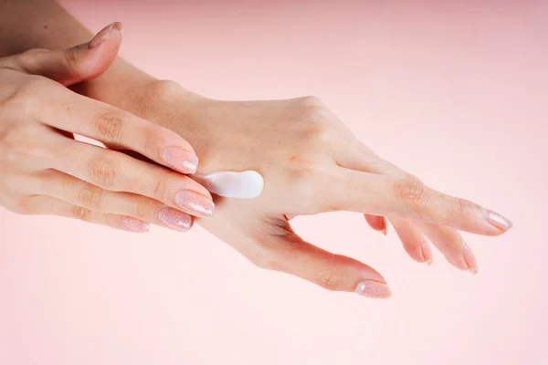 Mujer Mano Aplicando Crema Loción Aislada Sobre Fondo Rosa — Foto de Stock