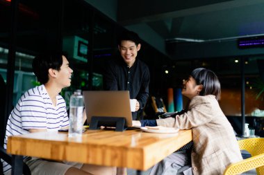 Kafe 'de bir grup Asyalı iş adamı proje planlıyor..