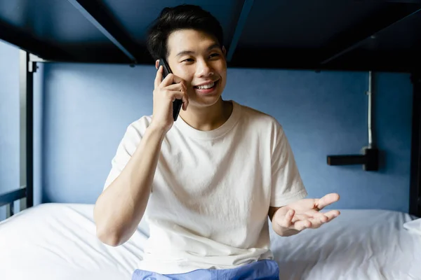 Ασιάτης Νεαρός Μιλάει Στο Τηλέφωνο Κοιτώνα Κρεβάτι — Φωτογραφία Αρχείου