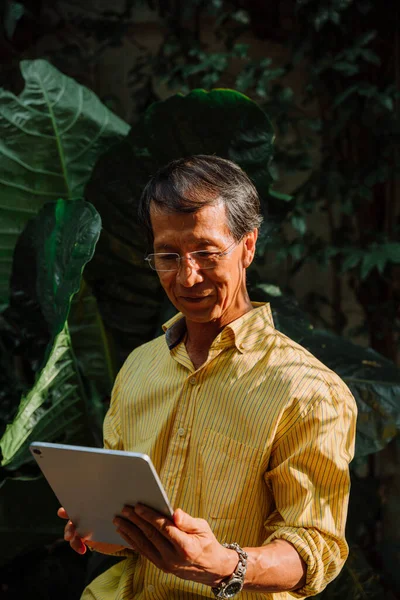Ασιάτης Ηλικιωμένος Κίτρινο Shirt Χρησιμοποιώντας Ψηφιακό Φορητό Υπολογιστή Στο Πάρκο — Φωτογραφία Αρχείου