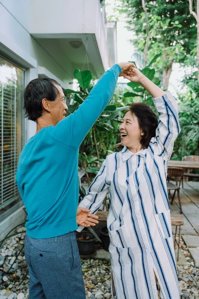 アジアの高齢者のカップルが裏庭で抱き合って踊る — ストック写真