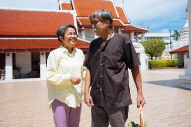 Asyalı yaşlı çift tapınakta el ele yürüyorlar..