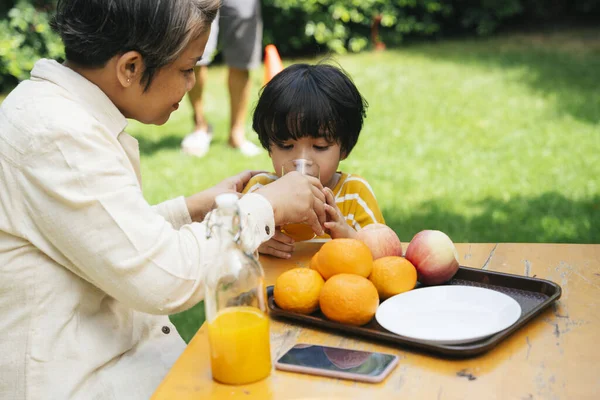 Азиатская Бабушка Внук Вместе Пили Апельсиновый Сок Парке — стоковое фото