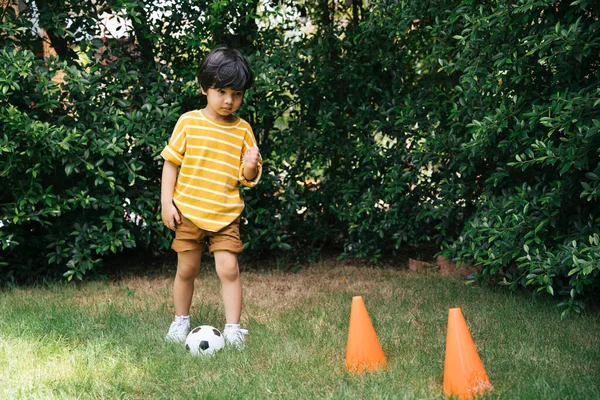 Asijské Chlapec Praxe Dribble Fotbal Kuželem Trávě Pole — Stock fotografie