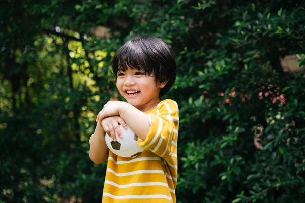 Веселый Азиатский Мальчик Держит Футбол Улыбкой Лице Парке Открытом Воздухе — стоковое фото