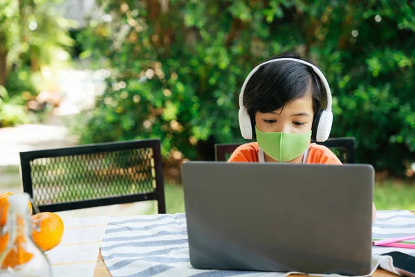 Asiático Niño Usar Máscara Escuchar Música Con Auriculares Uso Ordenador —  Fotos de Stock