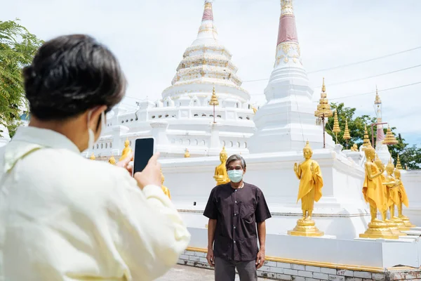 Yaşlı Bir Çift Maske Takıyor Tayland Tapınağında Akıllı Telefonuyla Fotoğraf — Stok fotoğraf