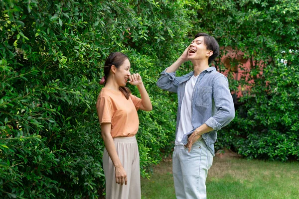 Bahçede Birbirleriyle Konuşan Neşeli Asyalı Genç Çift — Stok fotoğraf