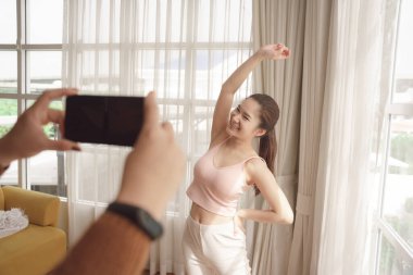 Genç Asyalı güzel kadın yoga yapıyor. Canlı yayın platformunda insanlarla birlikte..