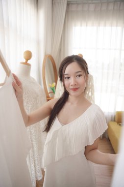 Gelinin güzel portresi. Asyalı kadın. Düğün töreni için elbise seçiyor..