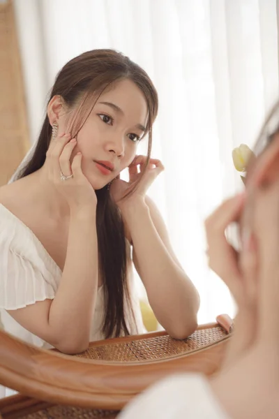 鏡の前にスキンケアクリームローションを塗る若いアジアの美容女性 — ストック写真