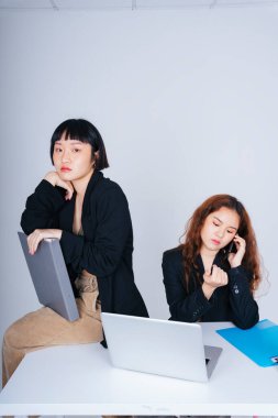 Resmi ceket giyen Asyalı iki genç iş kadınının portresi ofiste birlikte çalışıyor..