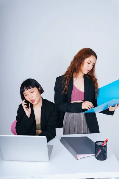 Portrait of two young business asian women wearing formal jacket suit working together in office.